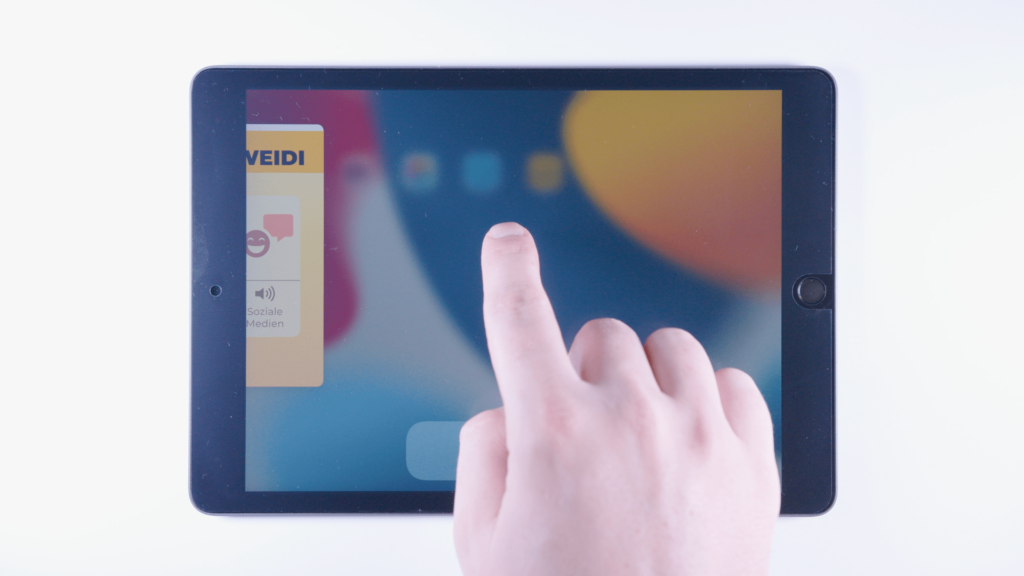 iPad: Ein Finger wischt nach oben, von rechts sieht man ein kleines App Fenster angedeutet.
