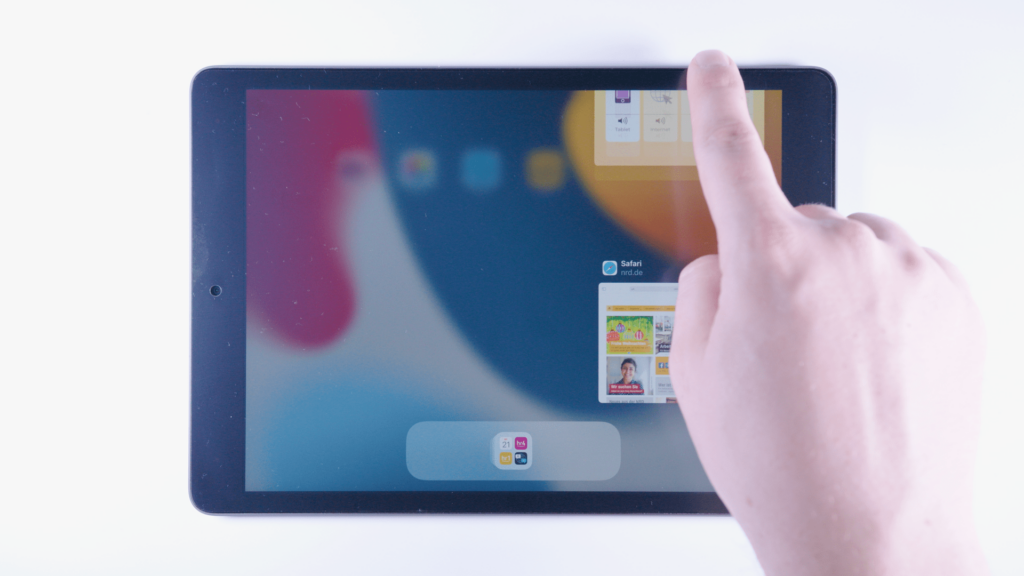 iPad: Ein Finger wischt ein kleines App Fenster nach oben.