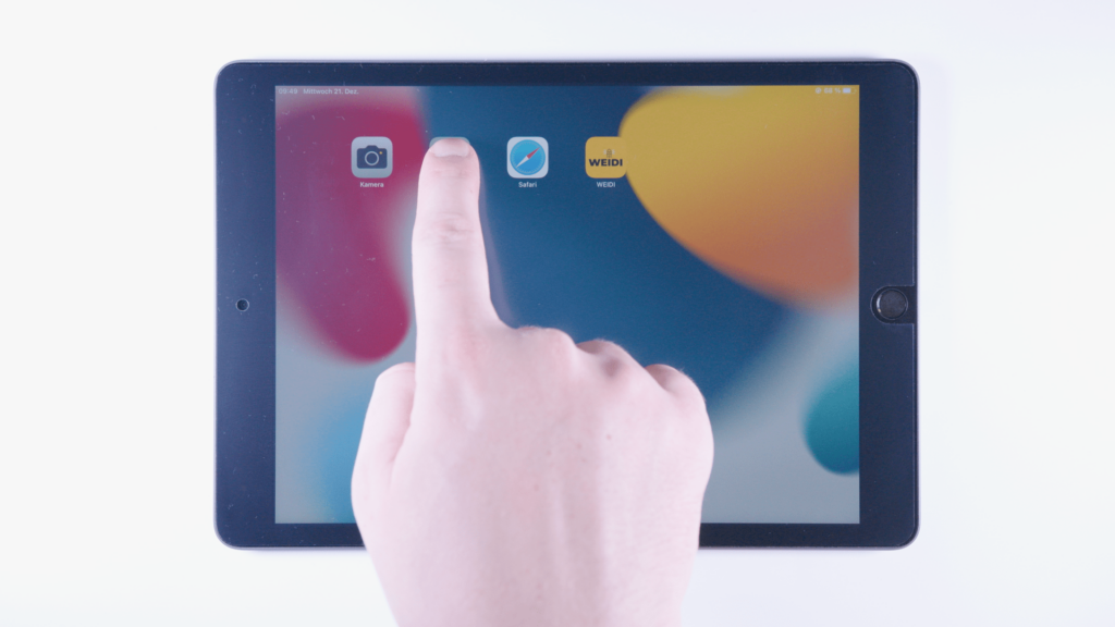 iPad: Ein Finger tippt auf eine App.