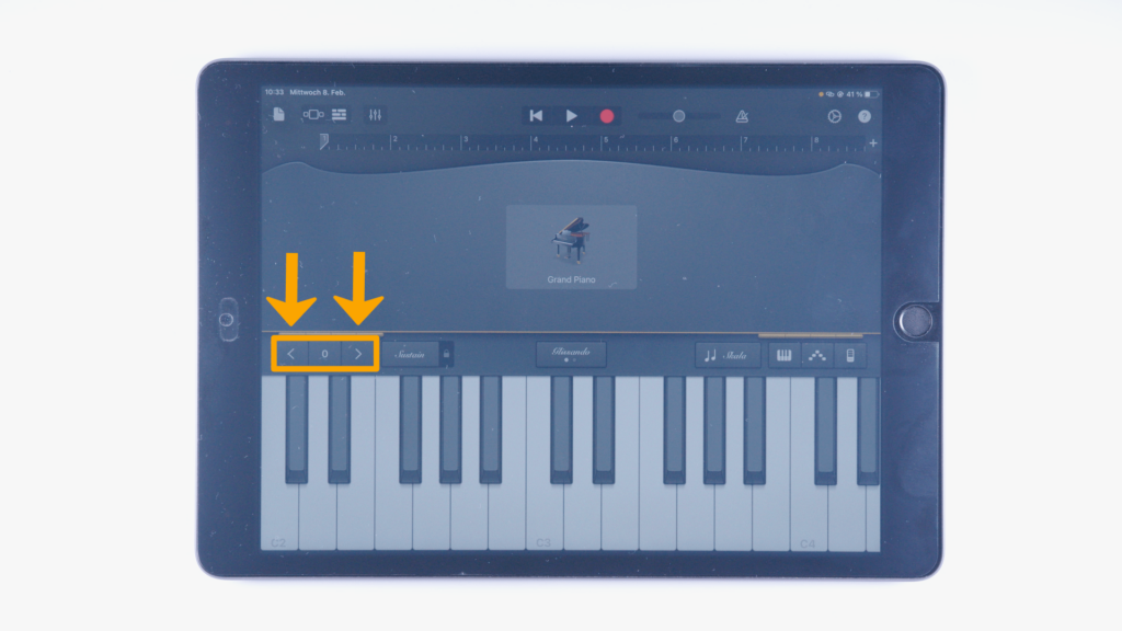 Ein iPad: Markierung der Tonlagen-Einstellung - links über der Klavier-Tastatur. Finger liegt darunter.