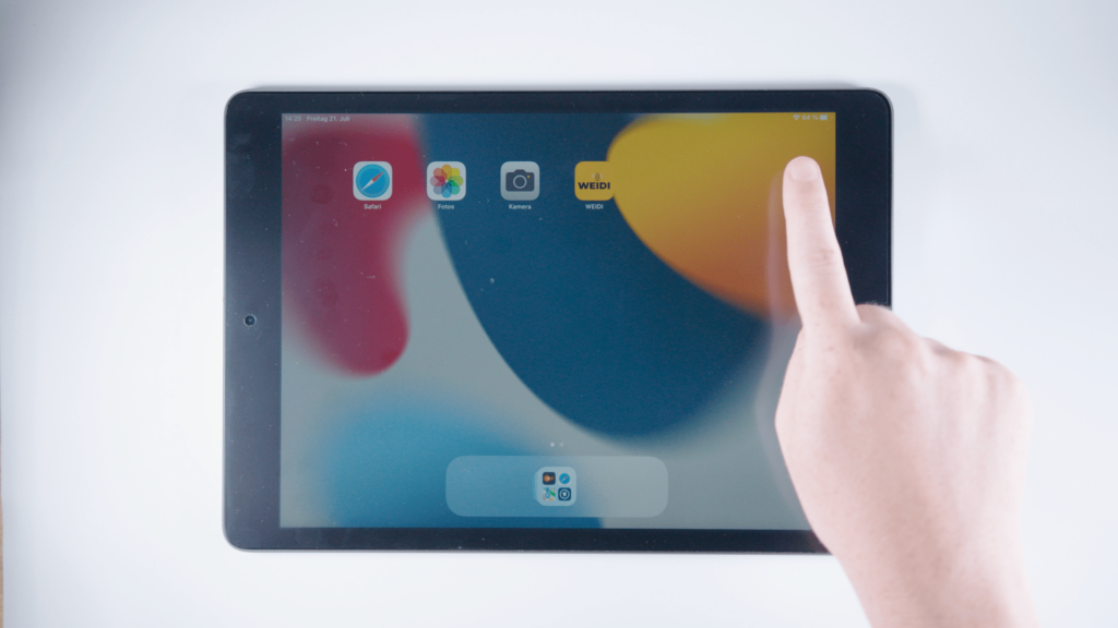 (iPad:) Startbildschirm: Finger auf dem Bildschirm; an der rechten, oberen Bildschirmecke