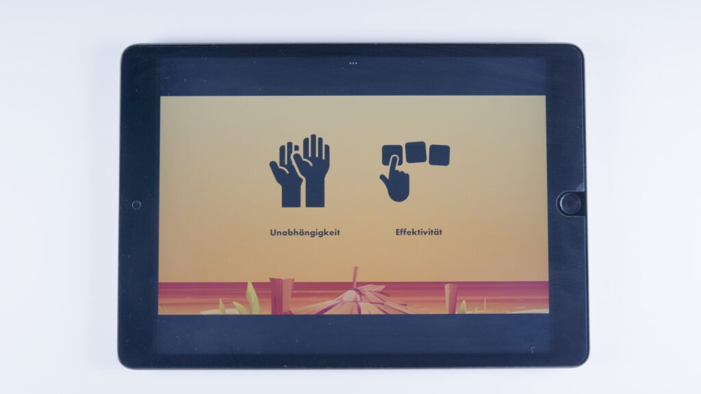 Tablet mit orangem Hintergrund. Links eine Darstellung von zwei aufgerichteten Händen mit dem Text „Unabhängigkeit“, rechts eine Hand, die auf drei quadratische Felder zeigt, mit dem Text „Effektivität“.