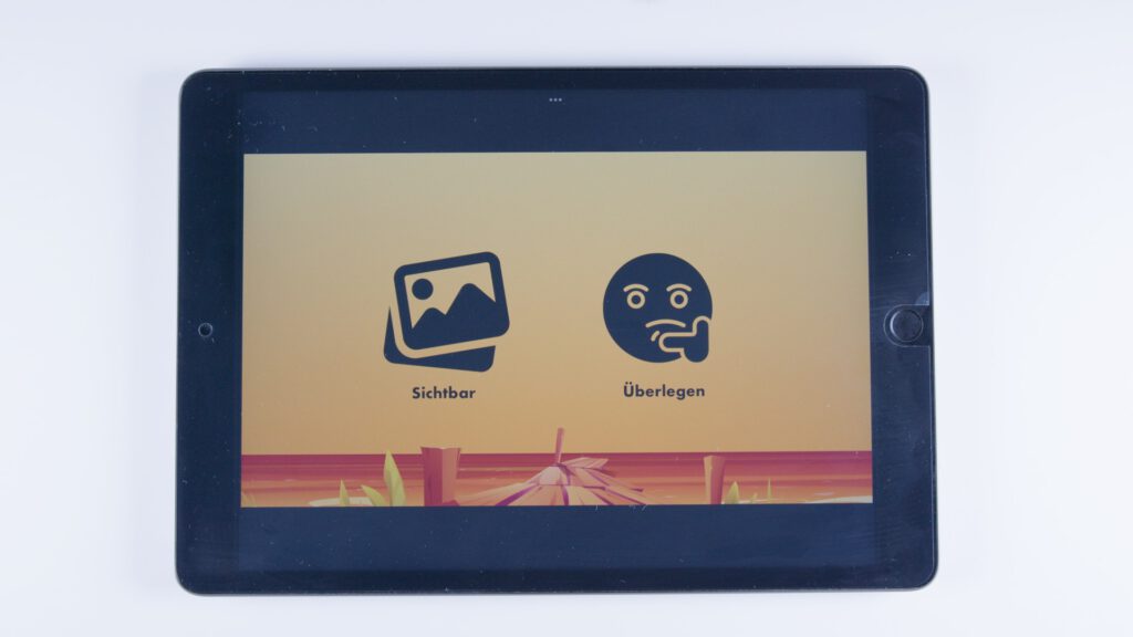 Tablet mit orangem Hintergrund. Zwei Symbole: links ein Bildsymbol mit Landschaft, rechts ein nachdenkliches Gesicht. Darunter die Begriffe „Sichtbar“ und „Überlegen“.
