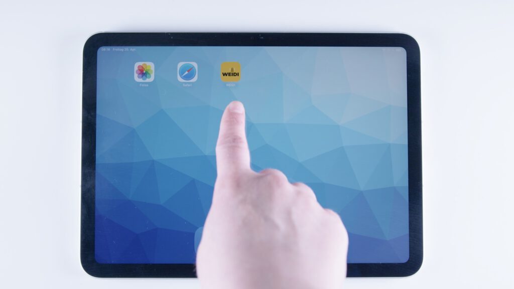 Tablet mit blauem Hintergrund. Eine Hand tippt auf das gelbe Icon der WEIDI-App in der oberen Reihe des Home-Bildschirms.